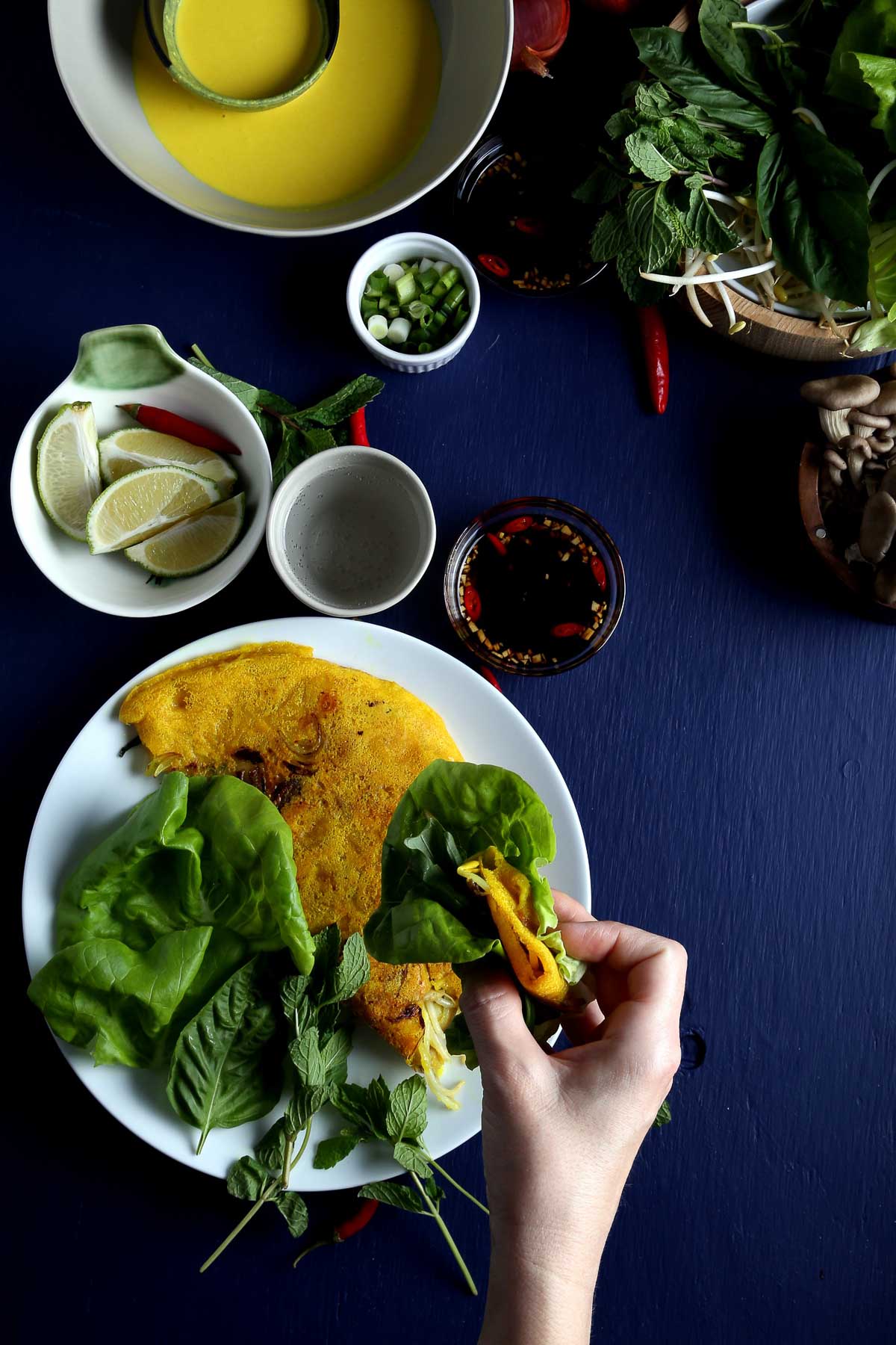 Bánh xèo with lettuce and fresh herbs.