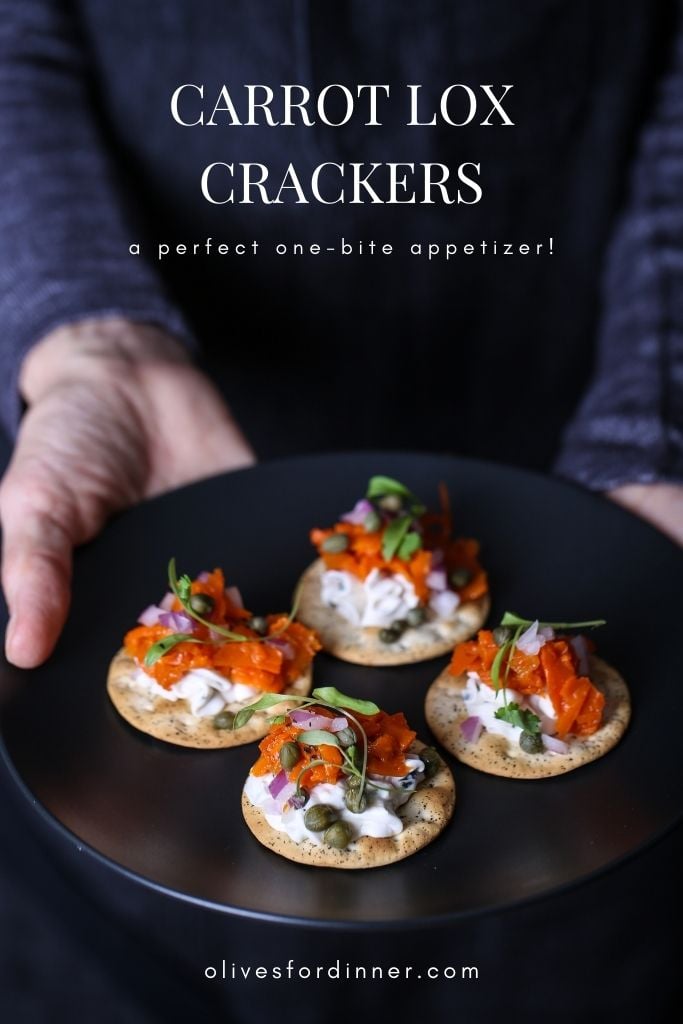 A plate of carrot lox crackers on a plate, against a dark background.