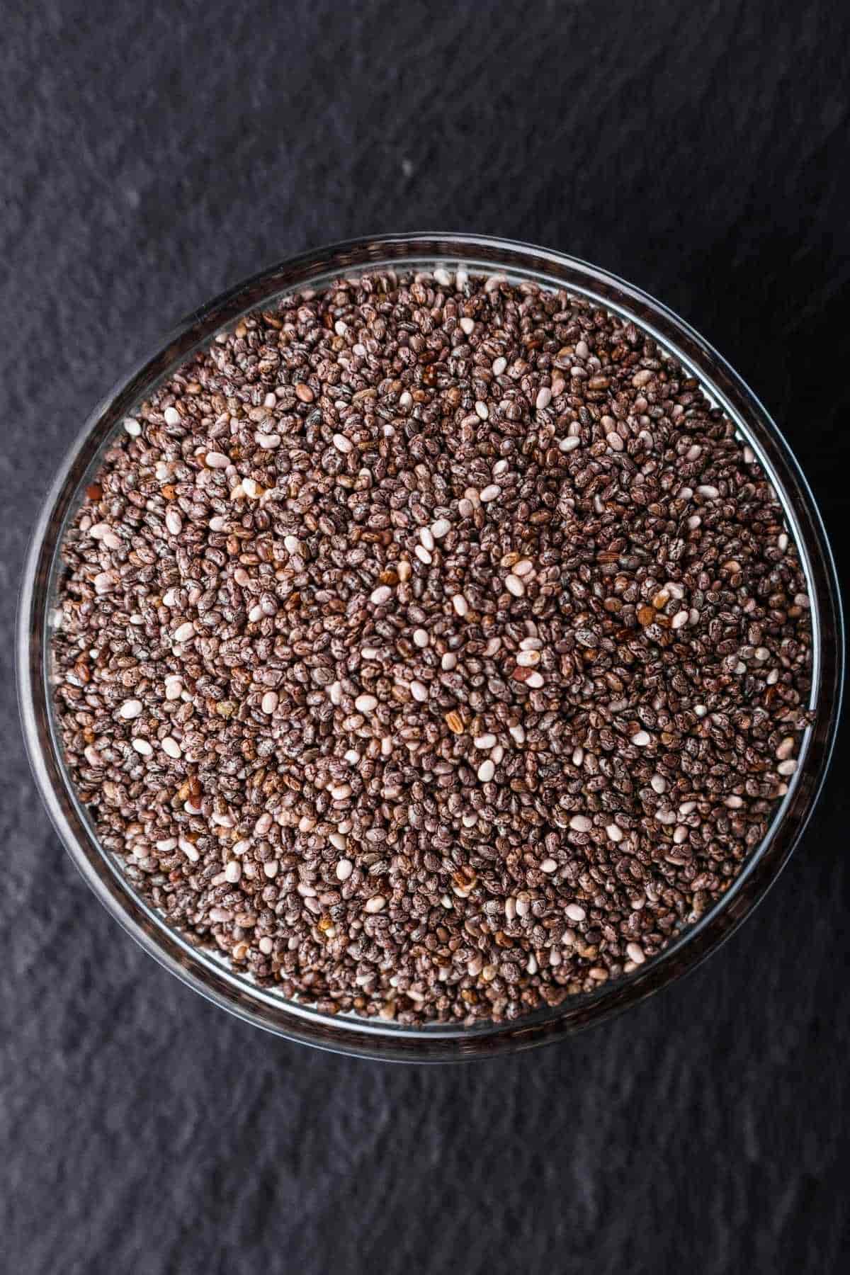 A glass jar filled with chia seeds, showcasing their texture and color.