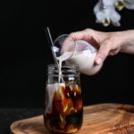 Vegan creamer being poured into a cold brew coffee.