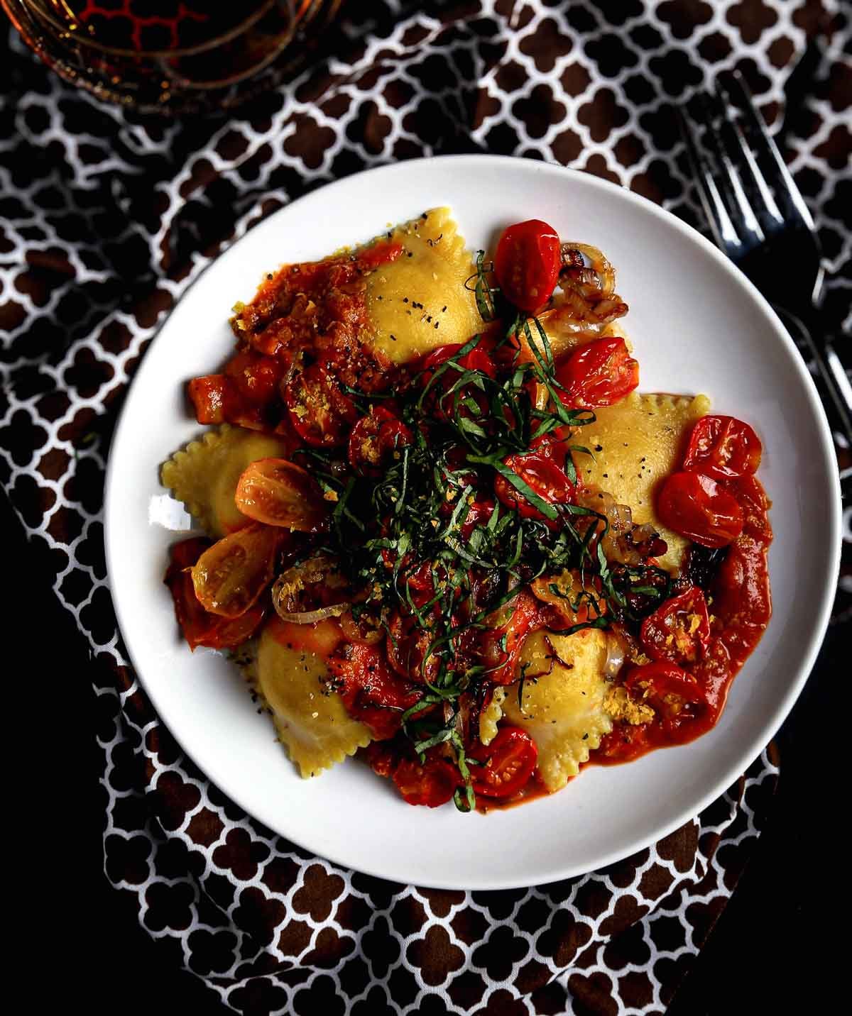 Ravioli topped with creamy tomato sauce and fresh basil.