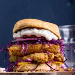 Crispy vegan fish sandwich on a toasted bun with cabbage and tartar sauce.