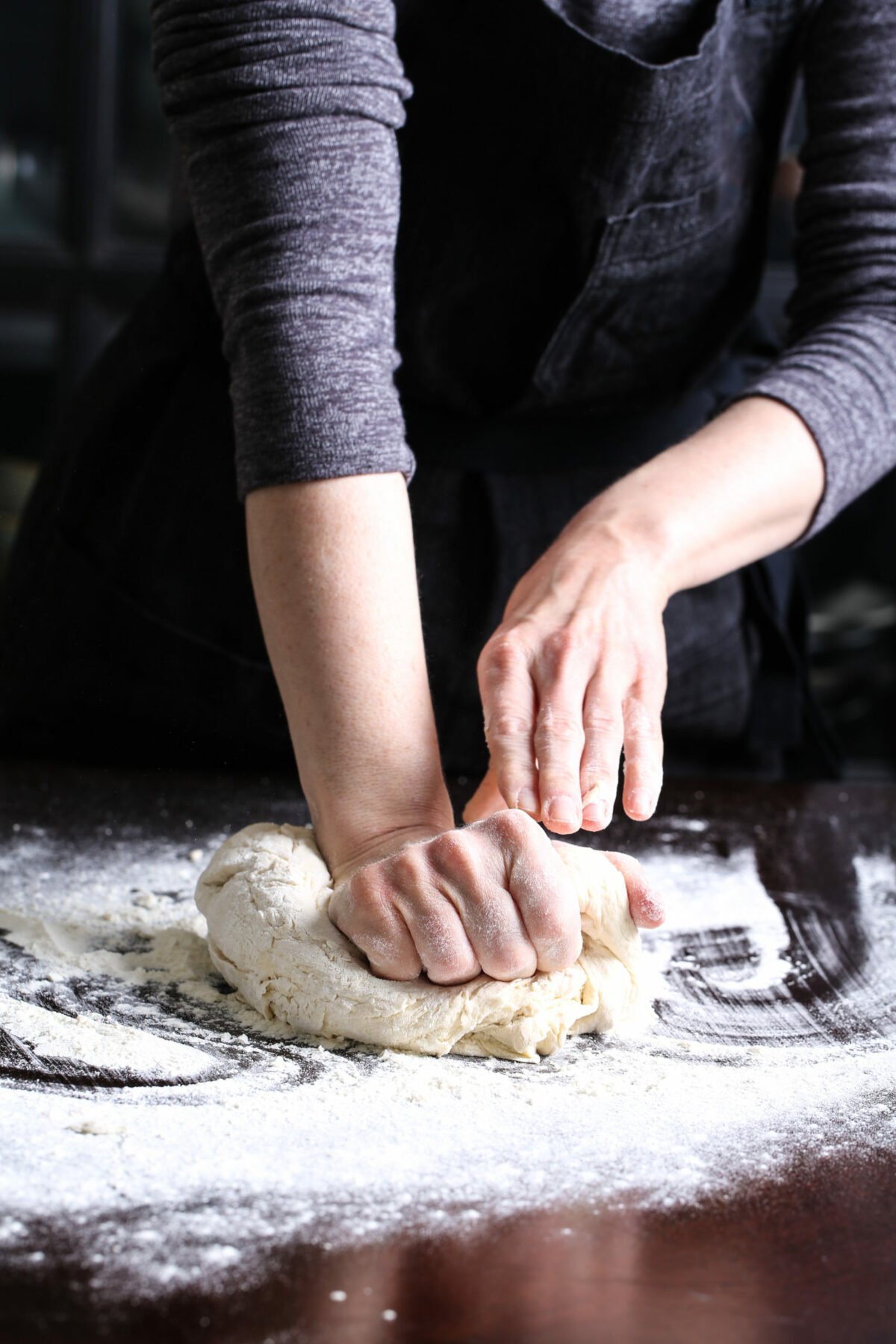 Two hands kneading dough.