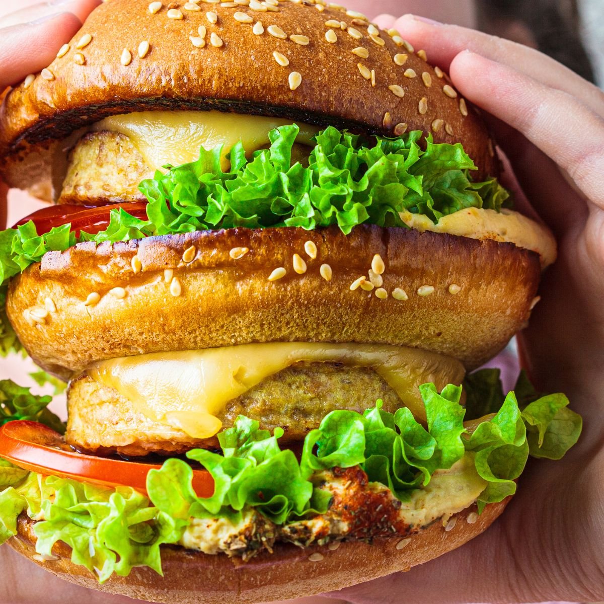 A double plant-based cheeseburger with lettuce and vegan cheese.