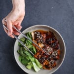 A bowl of spicy sambal tofu with wilted bok choy.