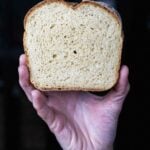 Slice of homemade sandwich bread held up to show its soft, even crumb texture.