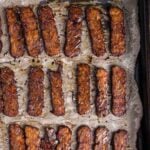Close-up of crispy baked tempeh bacon with glossy, caramelized edges and smoky glaze.