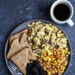 A shot of tofu scramble with toast, potato hash and berries.