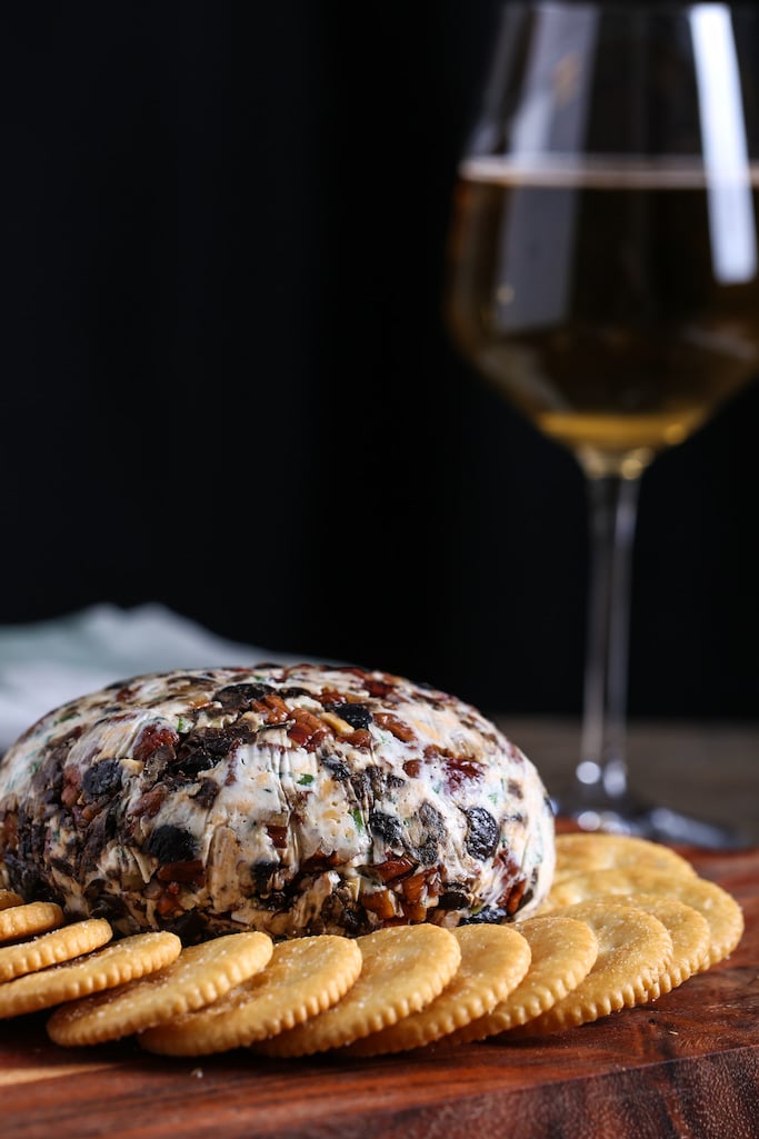 A vegan cheese ball on a plate with crackers.