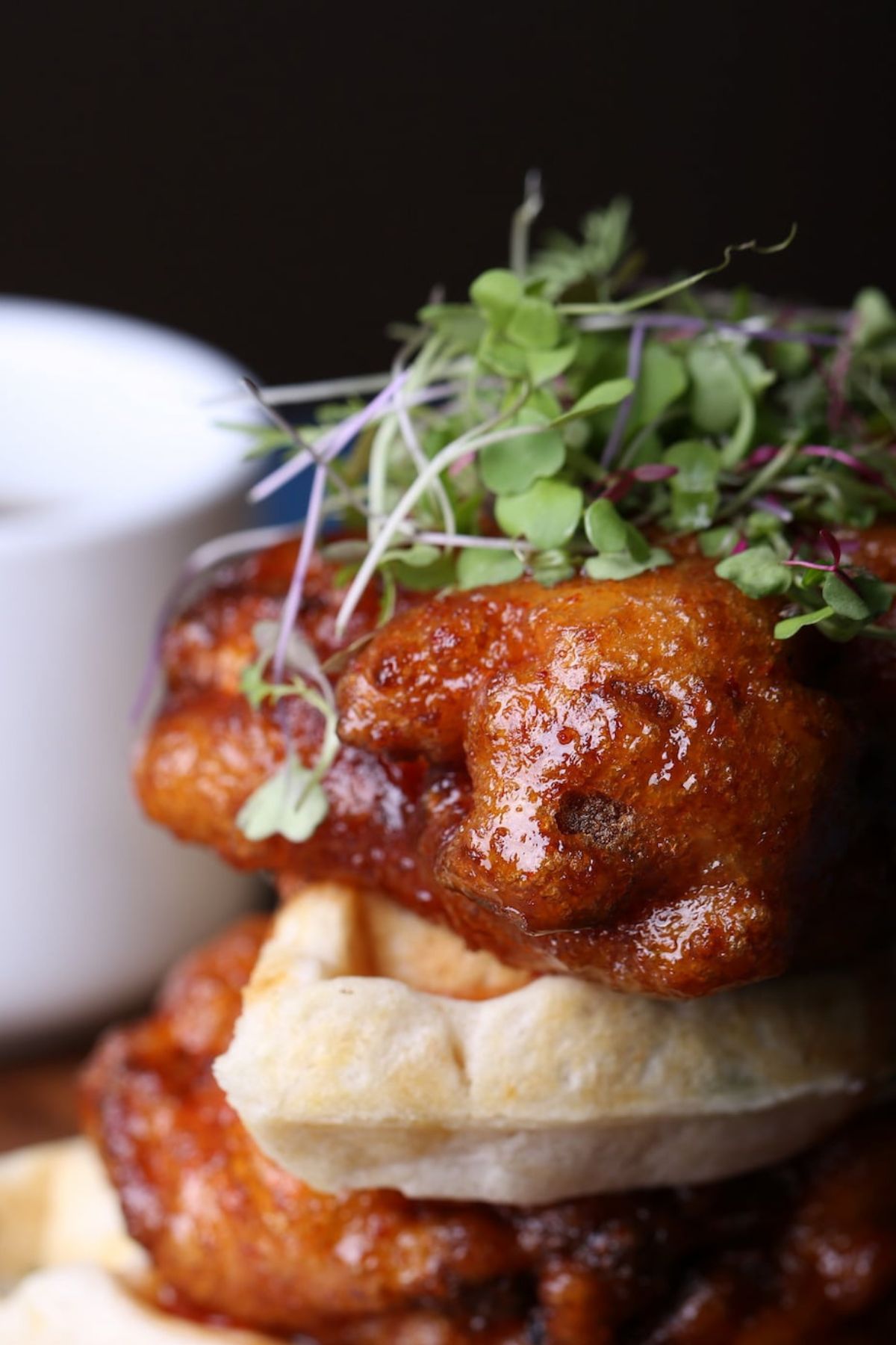 Vegan chicken and waffles with garnish.