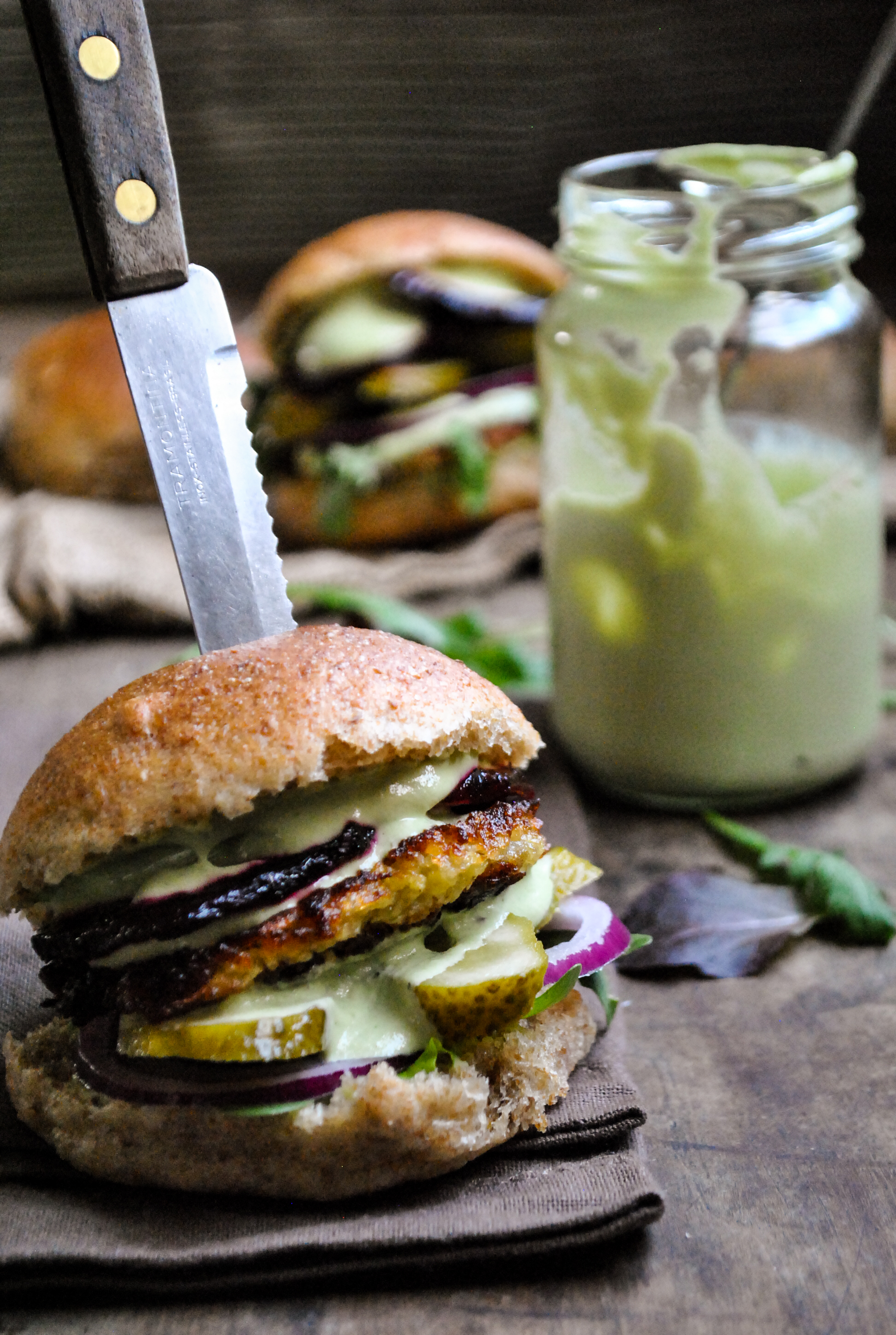 Vegan hash brown burgers with green sauce on a plate.
