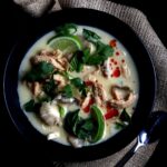 A bowl of tom kha soup with garnish.