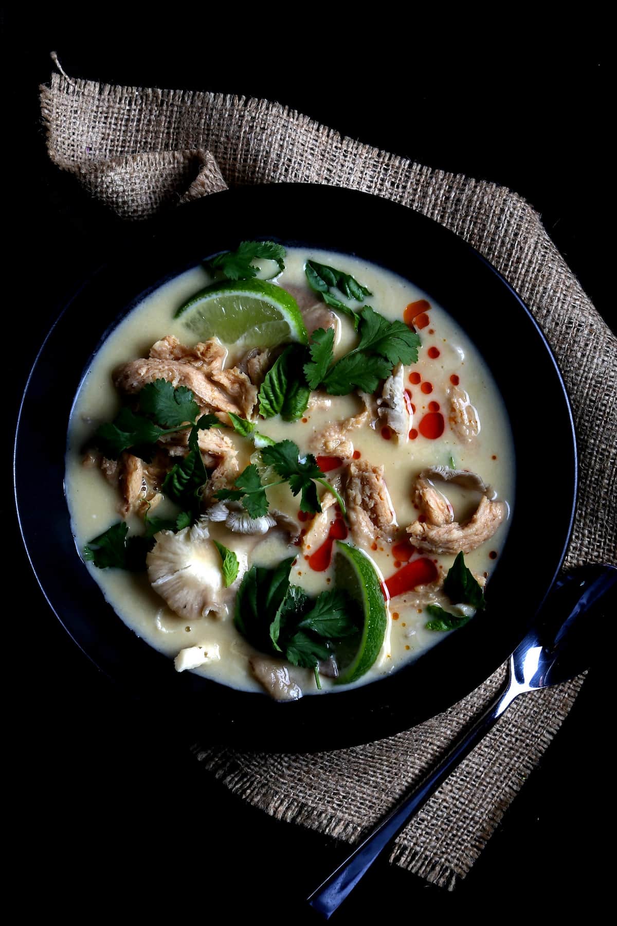 A bowl of tom kha soup with garnish.