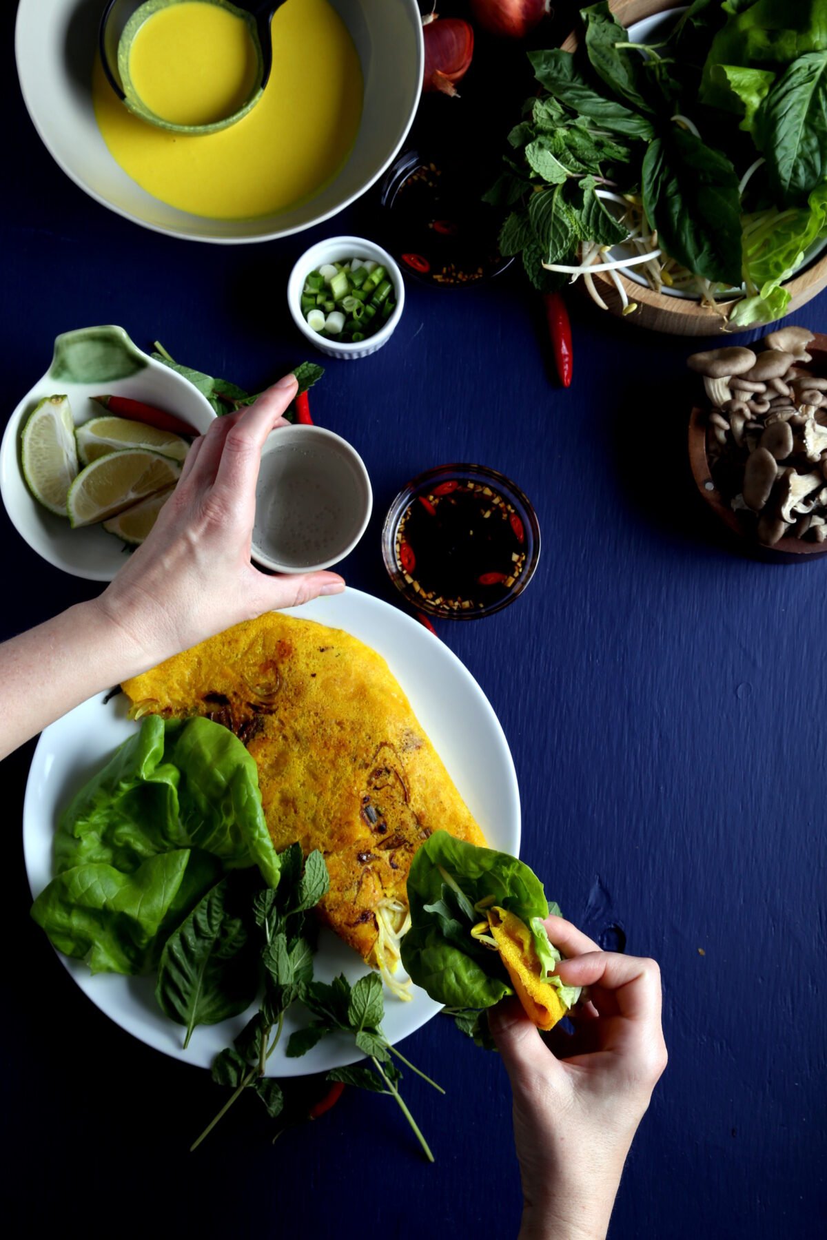 Vegan Banh Xeo, garnished with herbs.